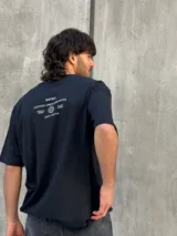 Remera negra oversize con cuello redondo y estampado pequeño en el pecho.