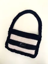 Cartera tejida a crochet con hilo 100% de algodón, con diseño a rayas y volados bordeando la cartera extendiéndose hacia la manija.