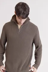 Sweater de punto color crema con cuello alto y cierre de cremallera parcial. Diseño de corte holgado y mangas largas.