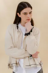 Saco tejido color negro con detalle en escote y puños a dos tonos, corte acampanado y detalle en la espalda con cambio de punto y color.