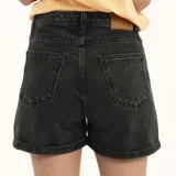 Short de jean negro con ruedo doblado.