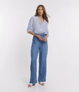 Pantalón pantalona de jean celeste, de corte ancho, con cintura media desplazada, pliegues delanteros y bolsillos.
