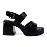 Sandalia de tacón alto negra con plataforma, diseño elegante y ajuste en el tobillo.