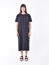Vestido negro de corte recto, largo midi y mangas cortas.