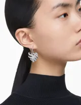 Aros colgantes Swarovski con forma de corazón, bañados en rodio y cubiertos de cristales transparentes. Cierre tipo gancho.