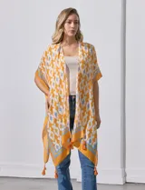 Kimono tejido color naranja con estampado geométrico en blanco y celeste, y terminación con borlas.