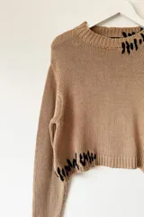 Sweater liviano de algodón en color tostado, con diseño amplio y detalles de intervención artesanal.