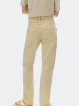 Pantalón cargo de mujer color beige claro, tiro medio/alto, con corte recto y detalles de costuras marcadas en el frente. Presenta bolsillos cargo amplios a la altura de los muslos.