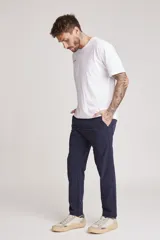 Pantalón de vestir azul marino, de corte recto, con bolsillos laterales y traseros. Se ajusta a la cintura con cinturón de cuero marrón.