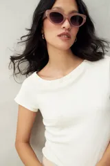 Top tejido azul marino de silueta ajustada con diseño minimalista y escote asimétrico, adornado con pequeños botones metálicos.