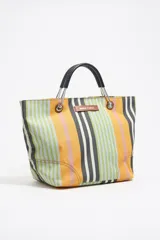 Bolso tote de tela a rayas verticales de colores naranja, verde, gris y rosa. Tiene doble asa corta de mano color negro y logo de la marca en etiqueta de cuero.