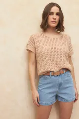 Chaleco tejido color beige con diseño calado, cuello redondo y mangas cortas.