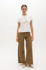 Remera blanca de algodón con estampado de dos flores en tonos pastel y logo de la marca en cursiva. Corte clásico y cuello redondo.