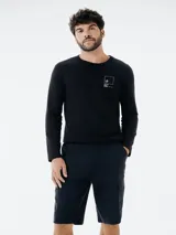 Camiseta de manga larga negra con estampado pequeño en el pecho.