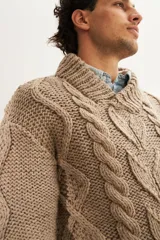 Sweater tejido a mano con ochos y cuello cruzado, color crema. Terminaciones en punto elástico en puños y ruedo. Hecho en Uruguay con lana fina sin teñir.