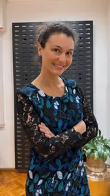 Vestido negro de manga larga, confeccionado en guipur bordado con flores azules y blancas.