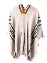 Poncho color rojo, con diseño geométrico en negro y bordes desflecados.