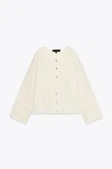 Chaqueta color crema de tejido de punto con lentejuelas, cuello barco, manga larga y cierre frontal con botones.