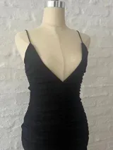 Vestido corto negro de microtul con escote en V y breteles finos.