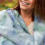 Pashmina liviana de gasa de algodón y lana Merino, predominantemente celeste con detalles en azul, verde, violeta y magenta.
