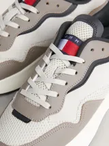 Zapatillas Tommy Jeans de estilo running, color gris con detalles en naranja y negro. Confeccionadas en piel y materiales reciclados.