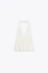 Top negro de cuello halter y escote pico con volantes en el bajo.