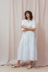 Vestido midi blanco de lino, con cuello camisero, mangas 3/4 y corte evasé.