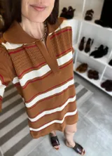 Vestido tejido a rayas horizontales color marrón, blanco y rojo, con cuello polo y cierre parcial con cremallera.