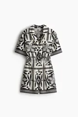 Mono corto con cuello abierto, botones forrados adelante y canesú en la espalda. Modelo de manga corta con cintura elástica, bolsillos laterales discretos y bolsillos superiores con solapa. Estampado floral en blanco y negro.
