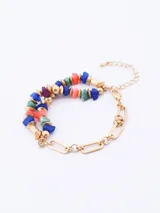 Pulsera elástica con cuentas de piedra irregulares en tonos azul, verde, rosa y morado, alternadas con cuentas doradas.