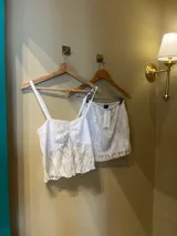 Pollera de encaje blanca con diseño ajustado al cuerpo y detalle de tirantes.