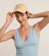 Gorra de sarga color amarillo con visera curva y bordado frontal de una concha de mar y texto "Riviera Beach Club".