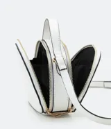 Bolso pequeño cruzado de forma redondeada, color negro con detalles en blanco. Tiene correa ajustable, tirante de mano y cierre de cremallera.