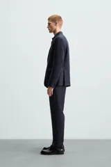 Blazer azul marino de lino con corte regular fit, cuello con solapas de muesca, manga larga con puños abotonados, bolsillo de vivo en el pecho, bolsillos de solapa en la cadera, bolsillo interior, aberturas en la espalda y cierre frontal de botonadura.