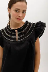 Vestido corto celeste de lino, corte suelto, con cuello redondo con volados y lazo, mangas cortas con volados.
