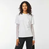 Camiseta blanca de manga corta con top de encaje blanco de manga larga debajo.