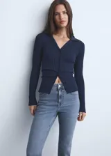 Jeans de mujer color azul claro, de tiro alto y corte recto con bajo deshilachado. Cierre de cremallera y botón, trabillas y cinco bolsillos.