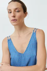 Top azul con estampado geométrico, breteles finos dobles y escote en V.