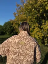 Chaqueta acolchada con estampado ikat en tonos beige y marrón, de corte holgado y cuello mao.