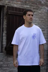 Remera blanca de algodón con cuello redondo y manga corta. Estampado pequeño en el frente de una mano haciendo el signo de la paz en color celeste.