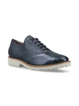 Zapato Oxford color bronce con detalles de perforaciones y suela blanca de goma.