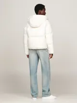 Campera puffer blanca de nailon con relleno de plumón, capucha fija, cierre de cremallera, puños elásticos y dos bolsillos delanteros.