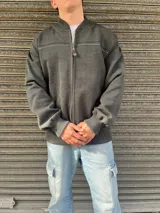 Campera gris de lana Merino con cierre frontal, cuello redondo y detalles de líneas horizontales en el pecho.