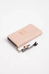 Billetera rosa con cierre de cremallera y detalle de rayo en relieve. Incluye llavero con dije de rayo y cinta estampada.