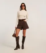 Short color marrón de tiro alto, corte mom, con trabillas en la cintura, bolsillos laterales y cierre frontal con botón y cremallera. Incluye cinturón marrón con hebilla rectangular.