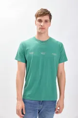 Remera de manga corta color verde con cuello redondo y estampado con texto en el frente.