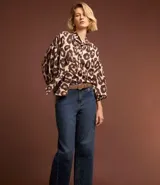 Pantalón de jean de corte recto con cintura alta, color azul oscuro, con bolsillos delanteros y traseros. Se ajusta a la cintura con cinturón de cuero marrón.