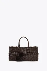 Bolso de mano con cuerpo trenzado color marrón oscuro. Tiene doble asa de mano, charm extraíble y bolsa interior con cierre fruncido.