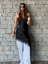 Vestido negro estilo slip dress, con tirantes finos y detalle de encaje en el ruedo y en el busto.