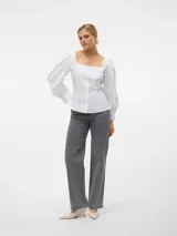 Camisa blanca de cuello cuadrado y mangas globo largas con puños abotonados. Cierre frontal con botones y calce regular.